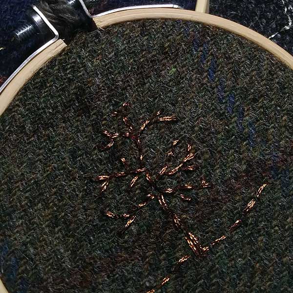 One of the ‘Tweed Collection’  A winter tree embroidered with copper metallic thread stitched on to grey Harris tweed. Supplied with contrasting crocheted  loop made with 100% British Wool. One available. 