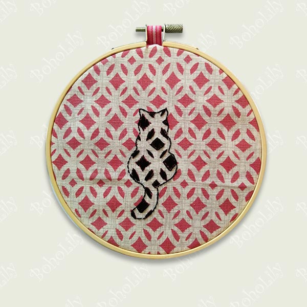 One for the cat lovers! A black geometric cat embroidered onto patterned dusky pink fabric.  The back of the hoop is covered with real wool felt in a rather fetching shade of plum! The hoop is supplied with contrasting ribbon hanging loop.