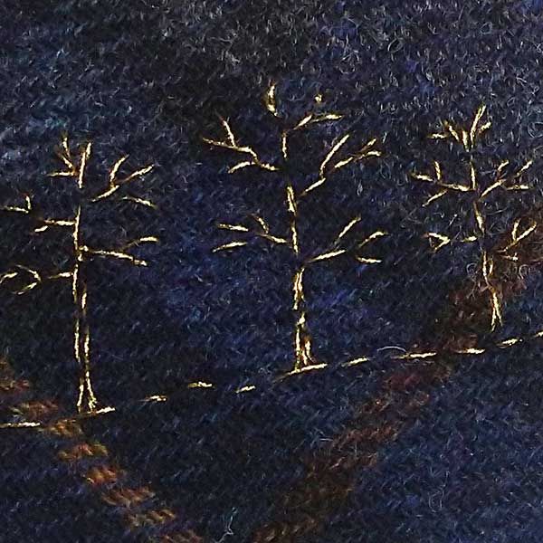 One of the ‘Tweed’ collection. Three winter trees stitched in gold metallic thread on to dark blue Harris tweed tartan. Supplied with contrasting crocheted loop made with 100% British Wool. One available. 